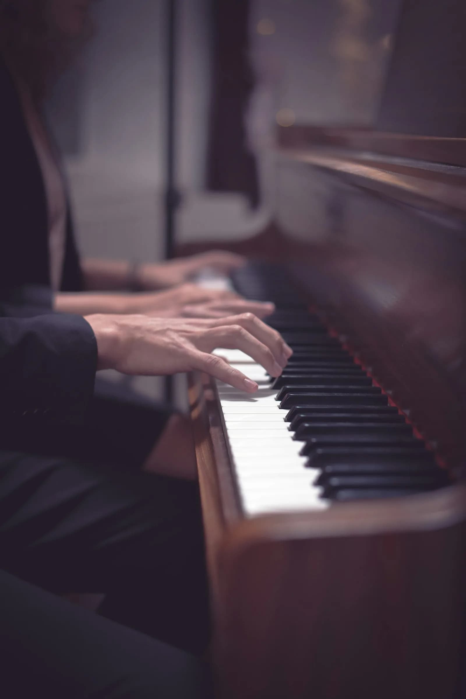 A pianist’s hands playing an acoustic piano